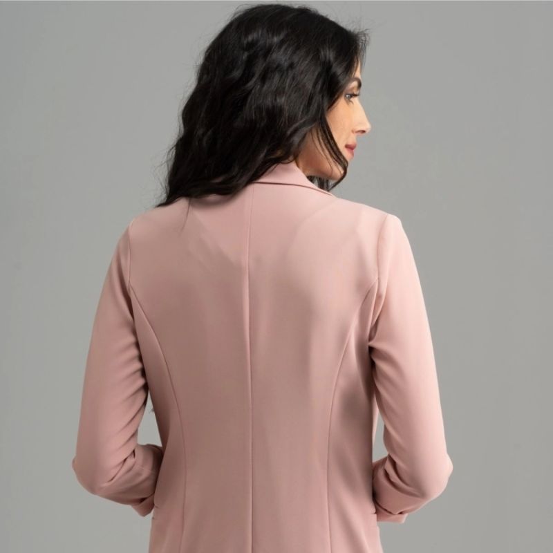 Donna di spalle che indossa una giacca stile blazer color cipria